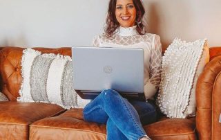 Angie sitting while holding a laptop